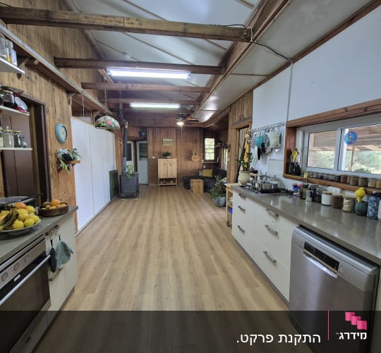 רצפת פרקט עץ בהירה במטבח כפרי עם קירות עץ.
